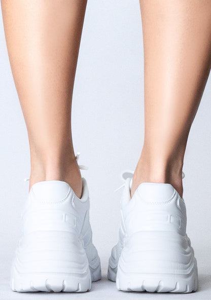 Close-up rear view of the chunky 2-inch white platform outsoles on-model, detailing the rugged grip built for festival comfort.