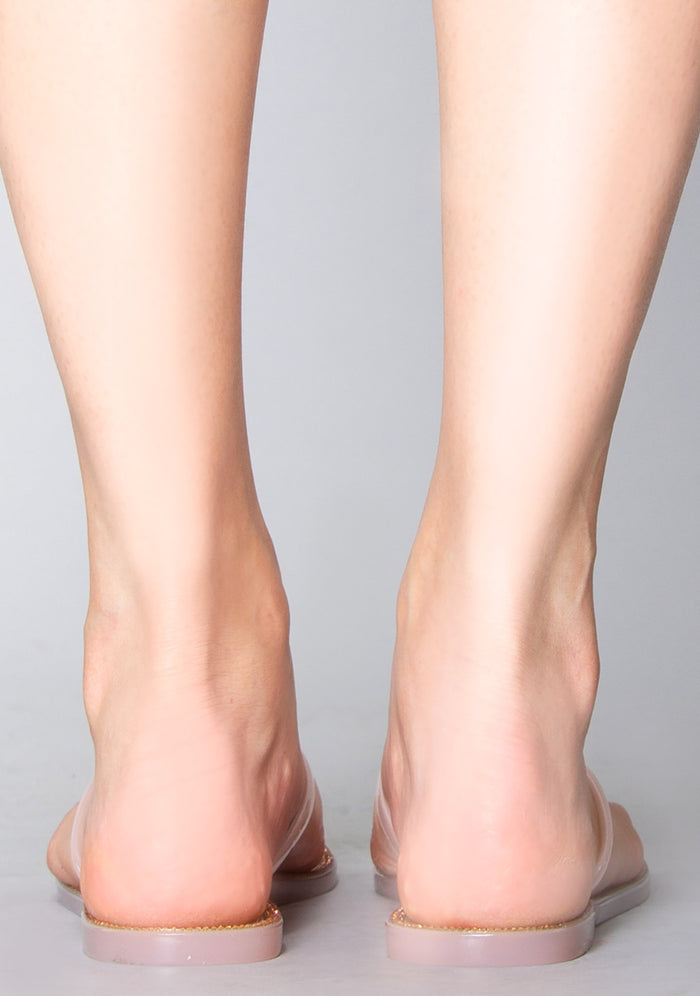 Rear view of the pink butterfly jelly sandals on-model, detailing the clean, minimalist flat heel structure and slip-on silhouette.