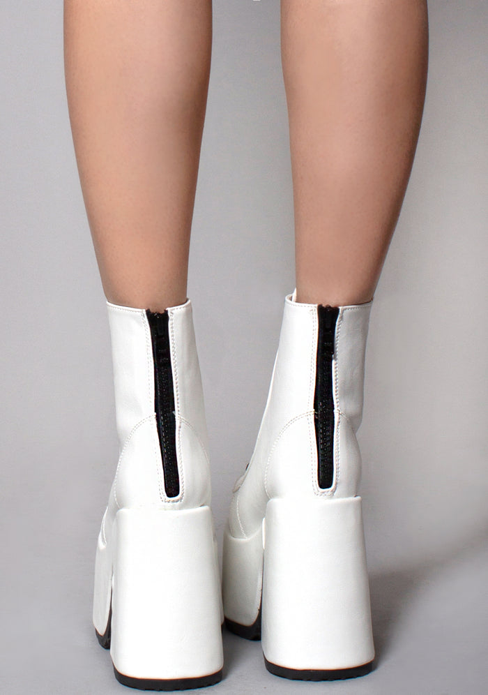 Demonia CAMEL 203 Deja Vu White Platform Boots in white vegan patent leather with metal back zip closure worn by model — back view