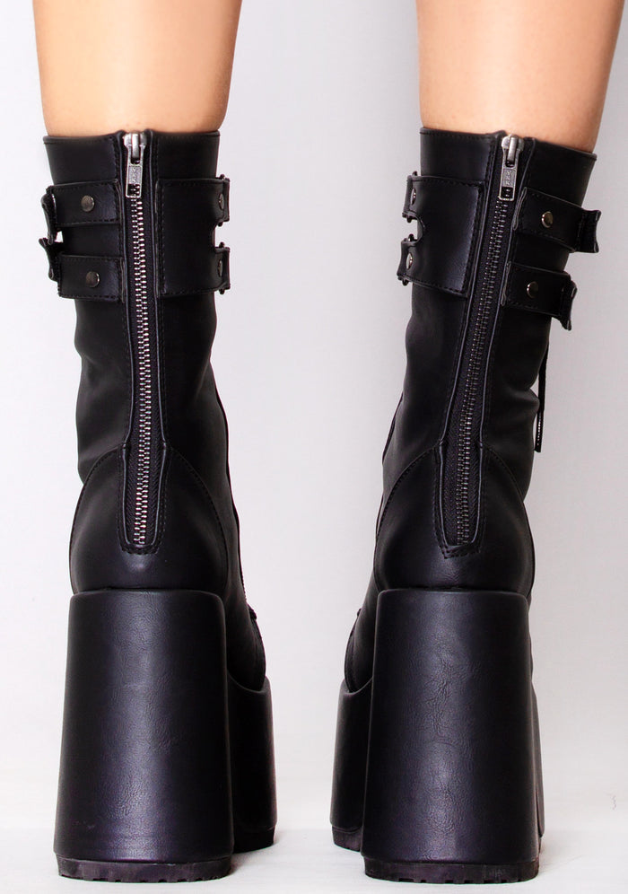 Demonia CAMEL 250 Night Dive Black Platform Boots in black vegan leather with back zip closure worn by model — back view