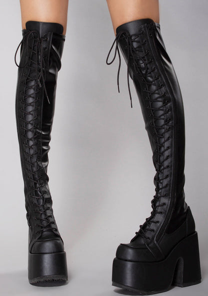 Demonia CAMEL 300 Rude Awakening Thigh-High Black Platform Boots in black vegan leather with 3 inch platform and full length metal zipper worn by model — front view