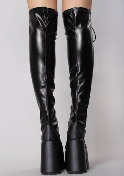 Demonia CAMEL 300 Rude Awakening Thigh-High Black Platform Boots in black vegan leather with full length metal zip closure worn by model — back view