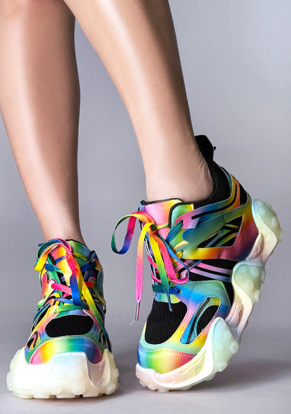 On-foot styling view from behind of Anthony Wang CARAMBOLA 03 Virtual Vibrance platform sneakers highlighting the neon pink, green, and blue wavy tentacle sole design elements