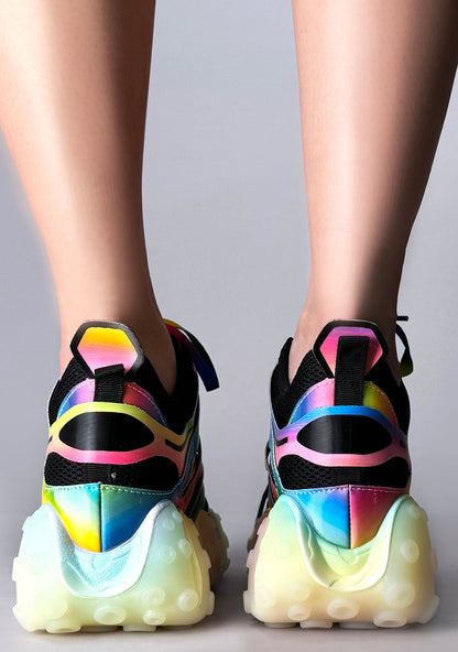 Studio shot from the back of Anthony Wang CARAMBOLA 03 Virtual Vibrance sneakers detailing the neon heel pull tabs, reflective multi-colored piping, and thick chunky high-traction tread