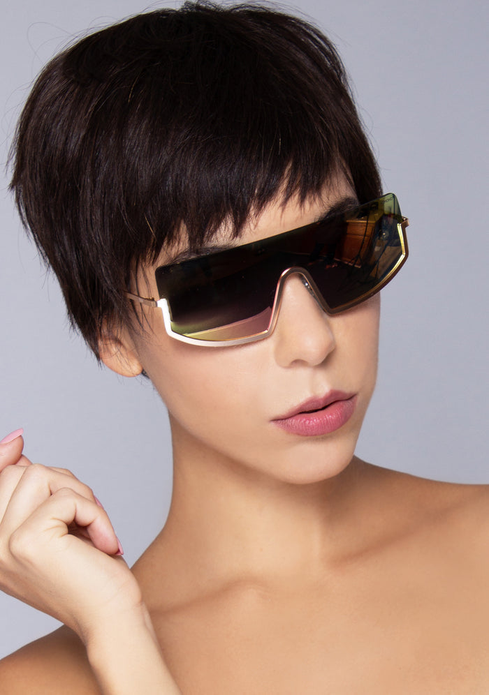 Komono CRAFTED Sonny Heat Sunglasses in pink with oversized curved frame and rose gold metal trim and pink gradient lens on festival sunglasses — model view