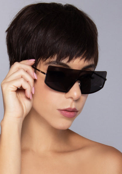 Komono CRAFTED Sonny Midnight Sunglasses in black with chic curved frame and matte black metal trim on festival sunglasses — model view