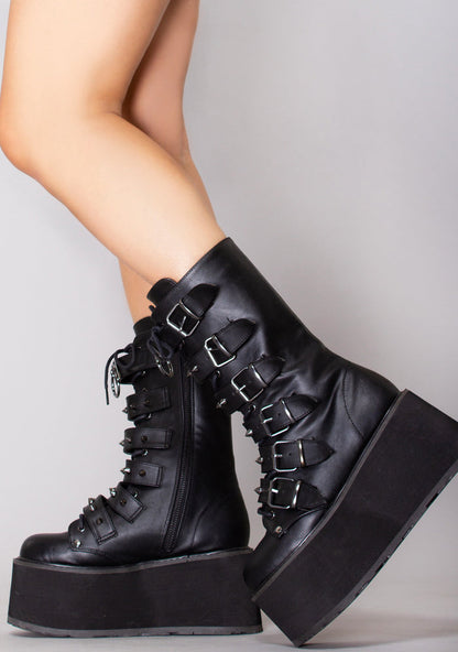 Demonia DAMNED 225 Dark Soul Black Platform Boots in black vegan leather with 6 buckle straps and lace-up front worn by model — side view