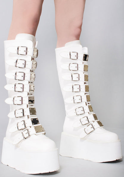 Demonia DAMNED 318 51/50 White Platform Boots in white vegan PU leather with buckle strap front worn by model — side view