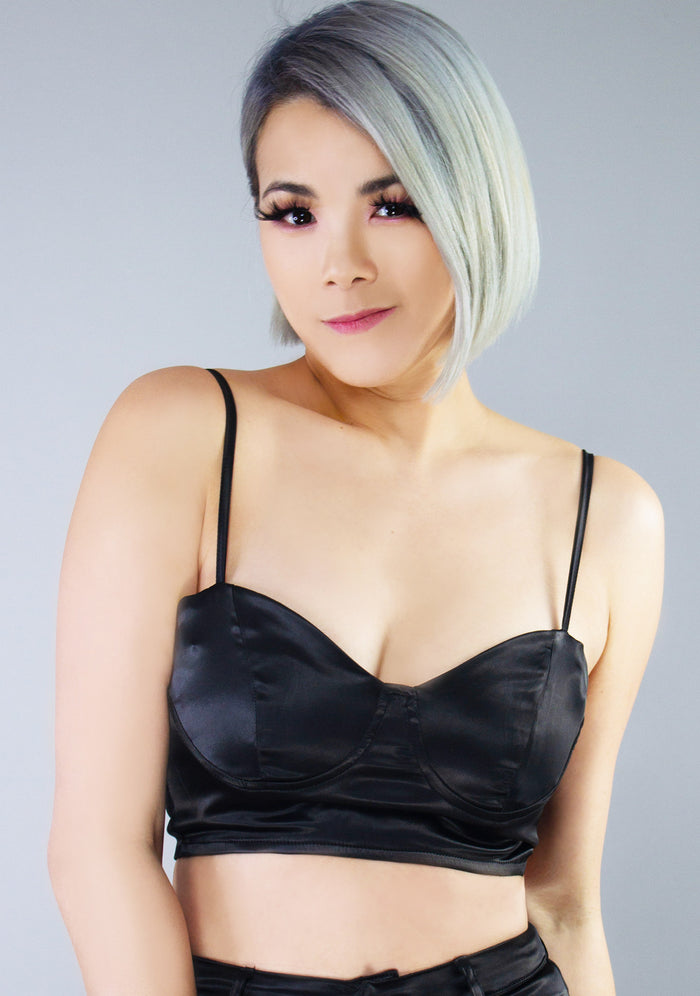 Hot & Delicious Glamour Fest Satin Bustier Crop Top in black with silky satin finish and metal zipper closure on festival top — model view