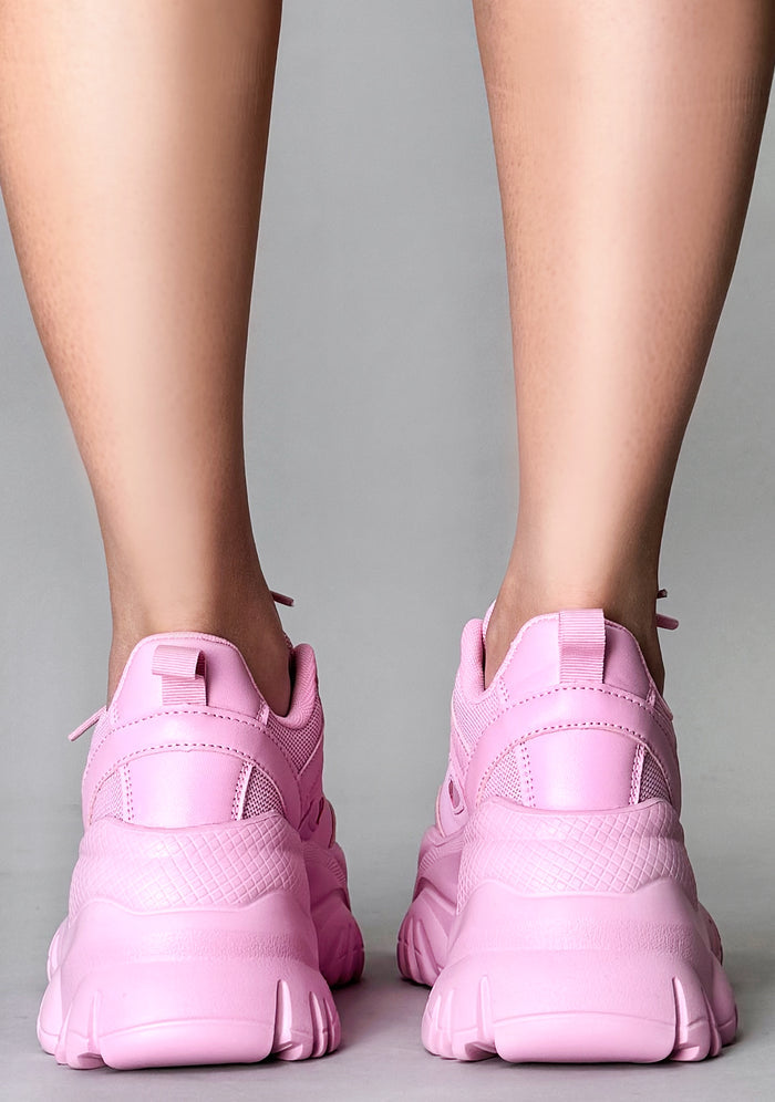 Close-up rear shot of the chunky 2-inch pink platform outsoles on-model, emphasizing the rugged texture built for festival comfort.