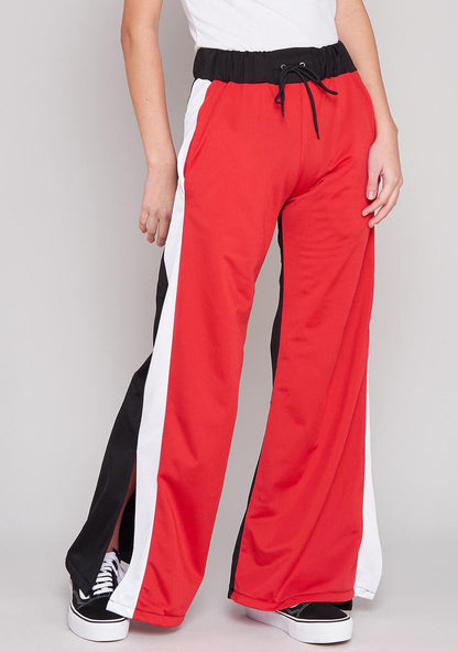 The Ragged Priest Jux Jogger Pants in red multi with stripe and split side detail on rave bottoms — front view