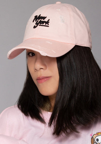 American Needle New York Shred Slouch Raglan Hat in baby pink with embroidered New York logo and distressed detail on cotton twill festival baseball cap — model front view