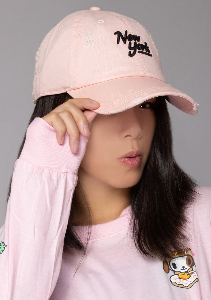 American Needle New York Shred Slouch Raglan Hat in baby pink with embroidered New York logo and distressed detail on cotton twill festival baseball cap — model side view