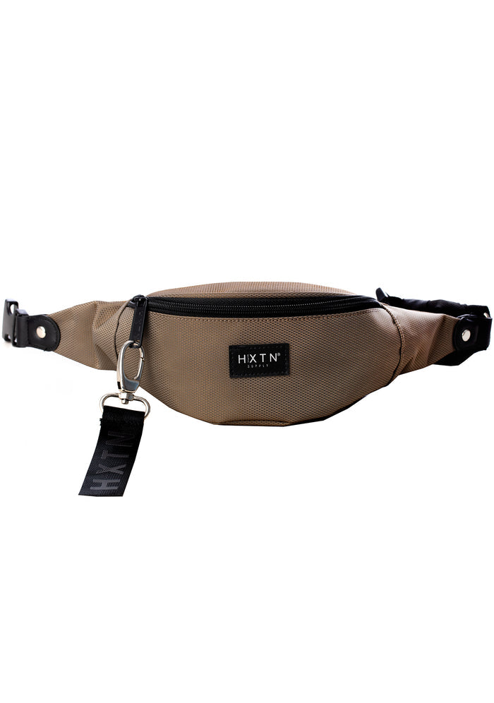 HXTN Supply Prime One Belt Bag in olive with zip-protected body and adjustable waist strap on festival rave belt bag — front view