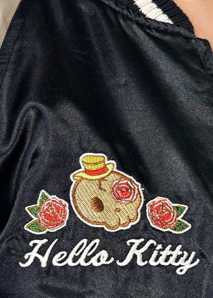 Sanrio Hello Kitty Rose Tattoo Bomber Jacket in black gold with Hello Kitty embroidery and rose tattoo design on satin fabric — embroidery detail view
