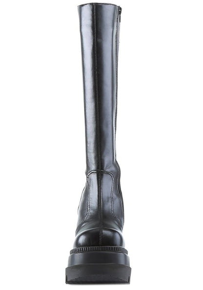 Demonia SHAKER 100 Total Blackout Black Platform Boots in black vegan PU leather showing 4.5 inch stacked wedge platform height — side view