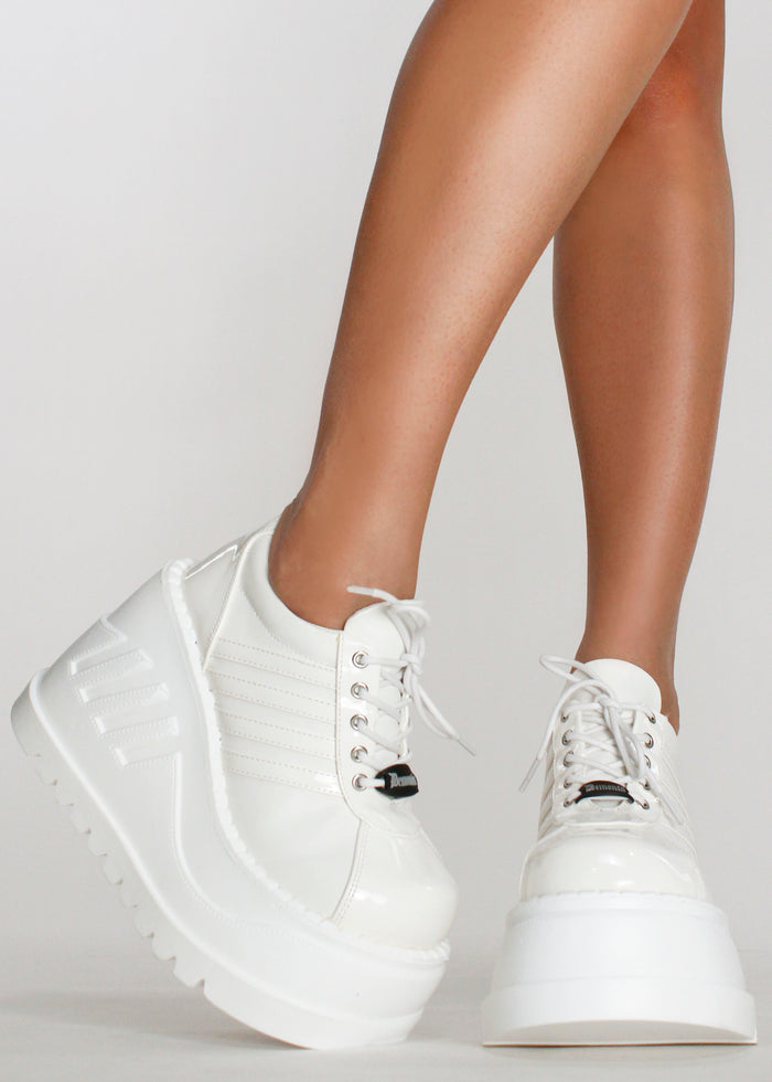 Demonia STOMP 08 White Rave Platform Sneakers in white matte patent vegan leather with sporty stripe worn by model — front view