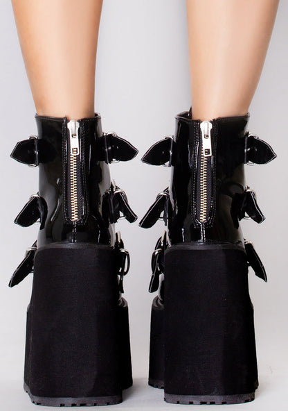 Demonia SWING 105 Dark Resistance Patent Black Platform Boots in black patent leather with back metal zip closure worn by model — back view