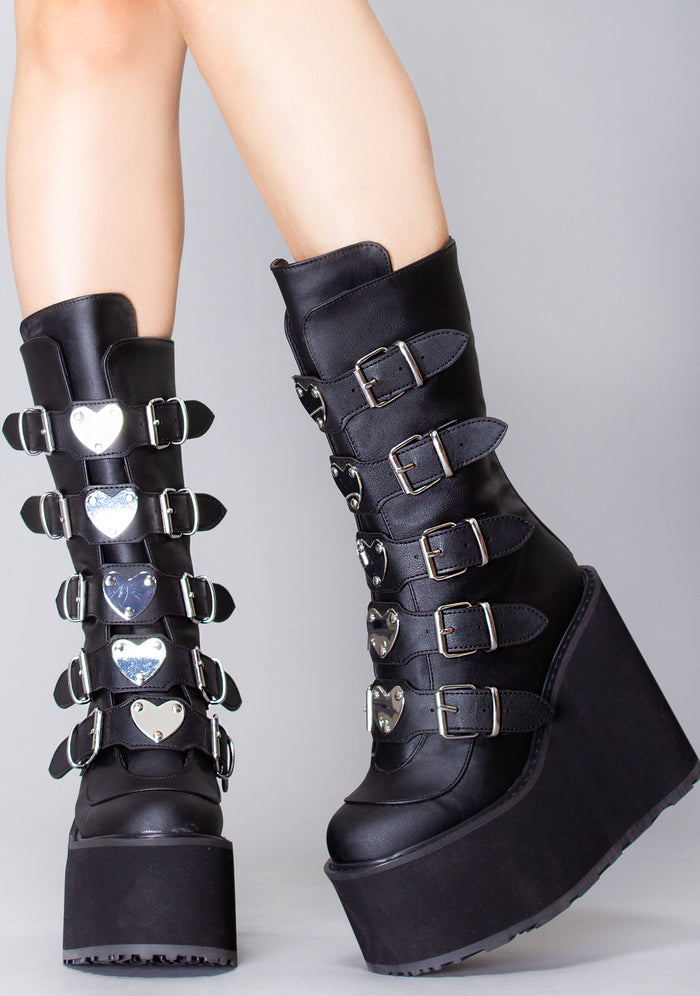 Demonia SWING 230 Black Heart Black Platform Boots in black vegan leather with 5.5 inch platform and heart hardware worn by model — front view