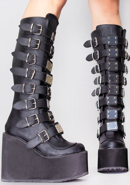 Demonia SWING 815 Beautiful Destruction Black Platform Boots in black vegan PU leather with silver plate buckle detail worn by model — side view